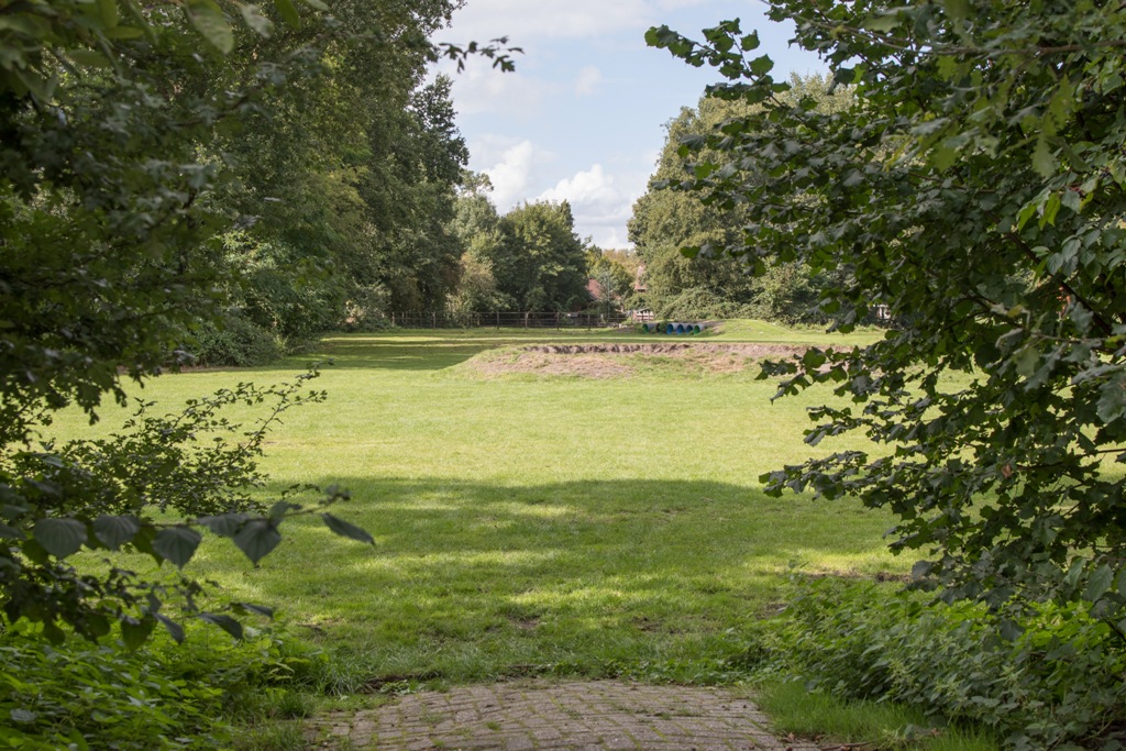 Grasveld met kampvuurkuil